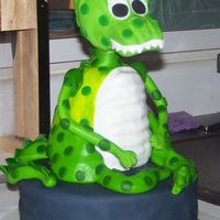 Dinosaur Birthday Cake 10" cake covered in Marshmallow fondant, with wondermold dinosaur body. The head is styrofoam, due to the heaviness.