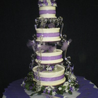 Liz's Wedding Cake Four tier weddingcake/chocolate, yellow, pumpkin and banana w/whipped icing, silk flowers. Design inspired by T. J.'s Custom Kakes as...