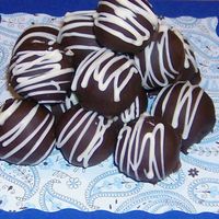 Cake Truffles Chocolate cream cheese cake truffles dipped in milk chocolate and drizzled with white chocolate.