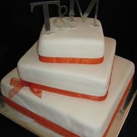 Square Wedding Cake 16, 12, 8" cakes covered in MMF and tied with an orange ribbon.