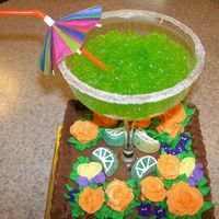 Margaritas For Her Birthday Orange flavored cake, with chocolate buttercream. The Margarita glass has lemon-lime jello in it. Buttercream and royal icing flowers.