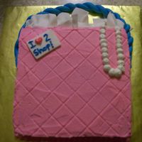 I Love To Shop Decorated to look like a shopping bag with Tissue made out of fondant rolled really thin and let to dry. Pearls made out of buttercream.