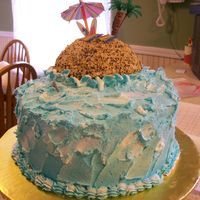 Birthday At The Beach Island in the ocean, with a toffee crunch topping. Tiki gods made ouf of a tootsie roll, and the towels out of candy.