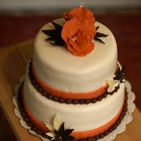Fall Colored Wedding Cake (Just A Practice Cake) I practiced doing a two tiered cake, and to cover with fondant. Flowers in gumpaste, and the leaves are made of chocolate.