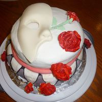 Phantom Of The Opera 2 tier cake covered in crusting bc and fondant. i made the mask out of white chocolate. I'm proud of this being my very first cake and...