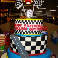 Matthew And Williams Race Car Cake White oval cakes with cream cheese filling and butter cream icing. Fondant decorations