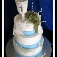 First Communion Cake This was a first communion cake for a boy. Cake is covered in buttercream with ribbon border. The chalice, host, leaves and swirls are all...