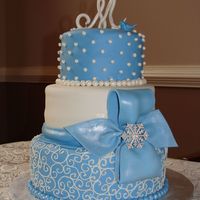 1451.jpg My Granny's 90th birthday cake. "M" and blue bird are made of gumpaste. Top is coconut cake covered in coconut flavored...