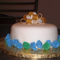 Anniversary/birthday This was on of my forswt cakes cakes. Cake covered in fondant with a gold fondant bow. Blue and green roses selected by the customer.