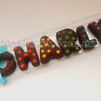 Name Alfajores Alfajores made in the shape of letters and covered and decorated with chocolate.