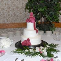 Wedding Cake With Burgandy Bow And Roses My first attempt at gumpaste. The cake was a 14" tiramisu; 10" Black Forest and 6" Tiramisu. Iced in buttercream. I thought...