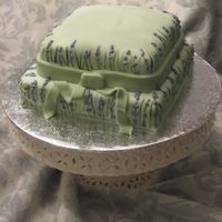 English Lavender Fonadant covered carrot cake with piped lavender flowers.