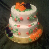 Two Tiered Wedding Cake Two tiered cake covered in Vanilla Buttercream with orange and dark purple roses