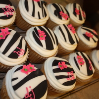 Zebra Cupcakes! Jumbo french vanilla cupcakes iced in buttercream with zebra print fondant circles and hot pink flowers. A few have the party guests and...