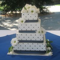 Black And White With Daisys And Tulips Diamond pattern with black dots. Larger black ribbon with smaller blue ribbon on the bottom of each tier.Fresh daisys and tulips. I am...