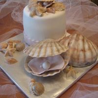 Sea Shells Gumpaste And White Chocolate Large open Sea shell with pearl and small open shell with pearl on the cake are gumpaste, the rest of the shells are white chocolate. Next...
