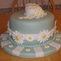 Daisies White cake covered with fondant. The daisies are a fondant/gumpaste blend.