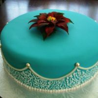 Mara's Birthday Chocolate fudge cake, teal rolled fondant, royal icing decoration and gumpaste poinsettia flower.