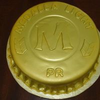 Beer Bottle Cap Chocolate cake filled with chocolate ganache, crumbcoated with chocolate buttercream, covered with fondant and air brushed with AmeriColor...