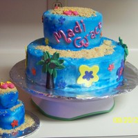 Luau buttercream with fondant accents, sand is graham crackers crushed and a smaller cake for the birthday girl