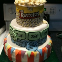 Carnival/circus Cake Three tier cake covered and decorated with fondant. Popcprn kernels made in advance of fondant and dusted with yellow dust; hand drawn...