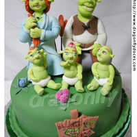 Shrek And Family Cake A cake inspired by Dreamworks' 'Shrek' movies, featuring gumpaste figurines of Shrek, Fiona and of the baby ogres triplets...