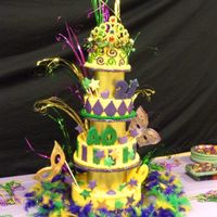 Mardi Gras Birthday Cake Celebrating Birthdays for 3 generations. Masks are made out of gumpaste and painted with lusterdust.