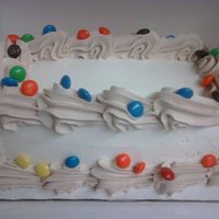 M&m Drops ice cream cake, paistry pride frosting, with fudge added for the border, topped with m&m's