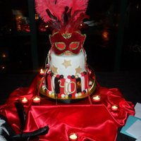 Masquerade Masquerade theme party cake, 3-tier, fondant covered and decorated, real mask on top, ordered online. I picked up a couple yards of satin...