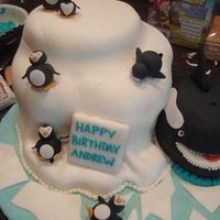 Antarctica Themed Cake Carved from three layers of chocolate, vanilla and strawberry cakes and covered in MMF. Orca whale is carved from a stacked oval shaped...