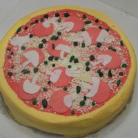 Pizza Cake This cake is done in Buttercream but the toppings are fondant. The cheese was made from white chocolate through a cheese grate.