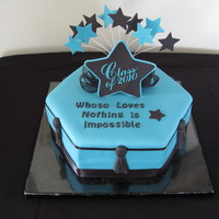 Fondant Graduation Cake 12" 2 layer hexagon with fondant and decorations of gumpaste. Gumpaste topper and tassels. Black satin ribbon trim.