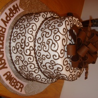 Brown Bow And Swirls Vanilla cake filled with chocolate buttercream. Bow is made from fondant and the swirls are royal icing.