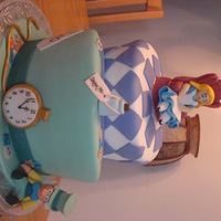 Alice In Wonderland This Alice in Wonderland Topsy Turvy cake is covered in fondant. I made Alice in her tea party chair, The Mad Hatter, Pocket Watch and...