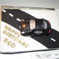 Porche Buttercream with fondant road and Porche made from Rice Krispie Treats covered in fondant. License plate used Birthday Boy's name.