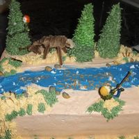 Hunting And Fishing Buttercream with gum paste/fondant caricatures, fish and gun. Deer is pipe cleaners, I couldn't figure out any other way to make him....