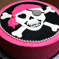 Skull And Cross Bones 3 tier yellow cake, filled with Nutella Buttercream. Pink Swiss Meringue Buttercream.Fondant decorations. Dragees on the eye patch for...