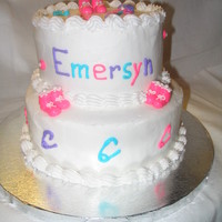 Baby Shower Cake Tiered Almond cakes with buttercream icing. Decorated with buttercream baby booties, rattle and safety pins, dots with pearl dragees....