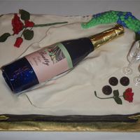 Wine And Roses Fondant cake, sugar wine bottle, gumpaste roses and chocolate candies.