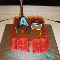 Rock N Roll Birthday 8in square iced in buttercream. Fondant "curtain" around sides, fondant vox amp and wires. Chocolate mold for electric guitar....
