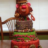 Tater Jones Graduation Cake This is my first cake using fondant. Except for Tater Jones on top, everything is edible. I used molds for the animals and chocolate rocks...