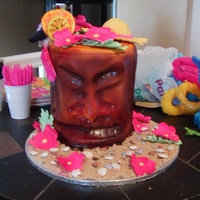 Tiki Man Tiki man cake. Decorated with fondant and airbrushed. The flowers are gumpaste and the shells and rockes are chocoate. It was a fun cake to...