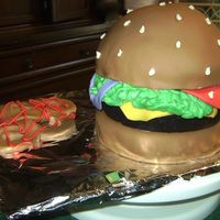 Hamburger And Onion Rings This is a hamburger cake with cheese, lettuce, tomatos, and onions served with a side of onion rings with ketchup.