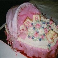 Bassinette A bassinette cake with eyelet lace and buttercream roses and chocolate blocks.