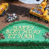 Construction Scene Birthday Cake 11 x 15 sheet cake,chocolate buttercream and white buttercream icing, #233 tip green grass, chocolate candy "rocks" in piles, in...