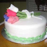 Tulips On A Cake Fondant tulip bouquet wrapped in fondant ribbon and bow.