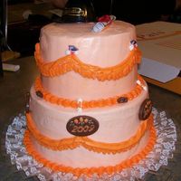 Grad Cake First time doing swags. Yellow cake with buttercream. The grad's school colors were black and orange. The decorations are plastic (on...
