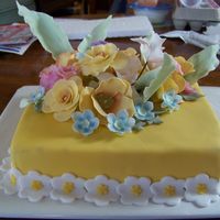Flower Garden Made this cake for Mother's Day. Plain old Chocoalte cake with BC filling. Covered in Yellow fondant. Sweet Peas, Roses, Tupils,...