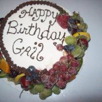 Sugared Fruit Birthday Cake yellow butter cake with butter cream and chocolate icing, decorated with fresh sugared fruit.