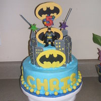 Batman Birthday Cake 2 Tier, 9 and 6 inch. Buttercream frosted, Royal icing buildings, Fondant letters and bat signals made from Royal icing (bottom one) and...